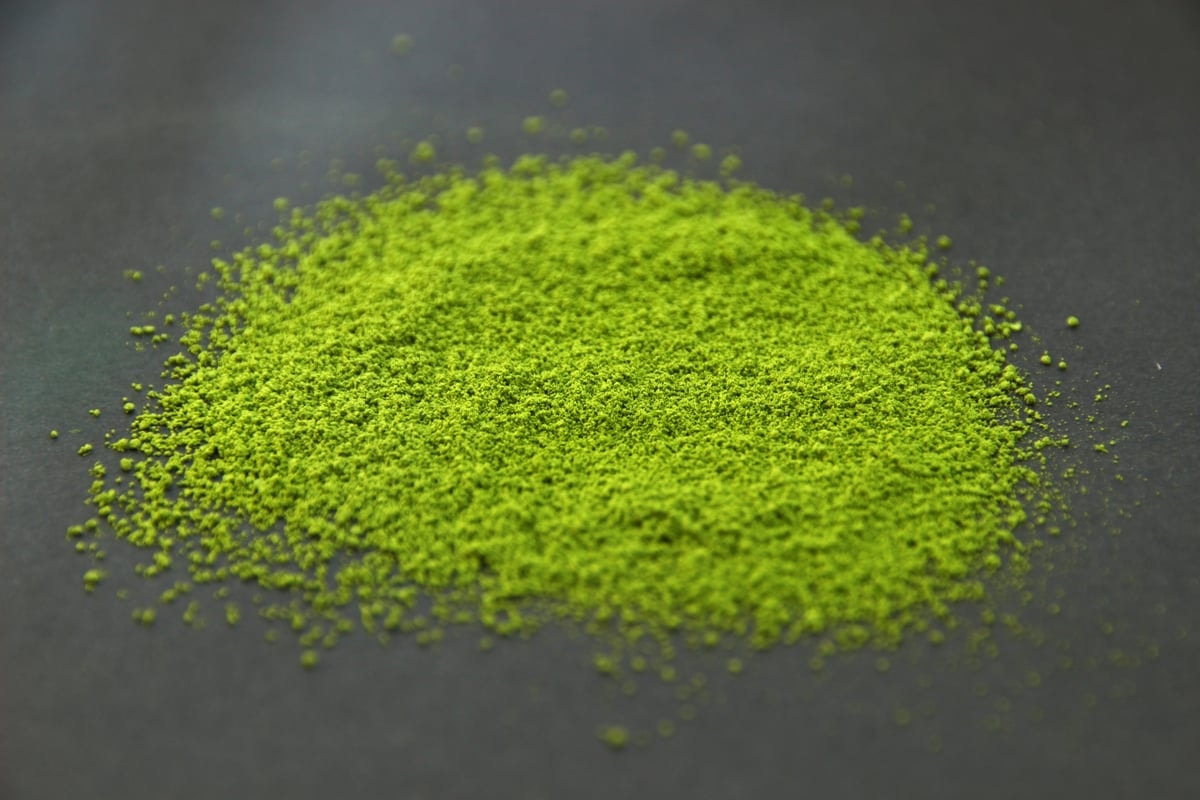 Vivid green matcha powder from Shizuoka heaped on a dark surface