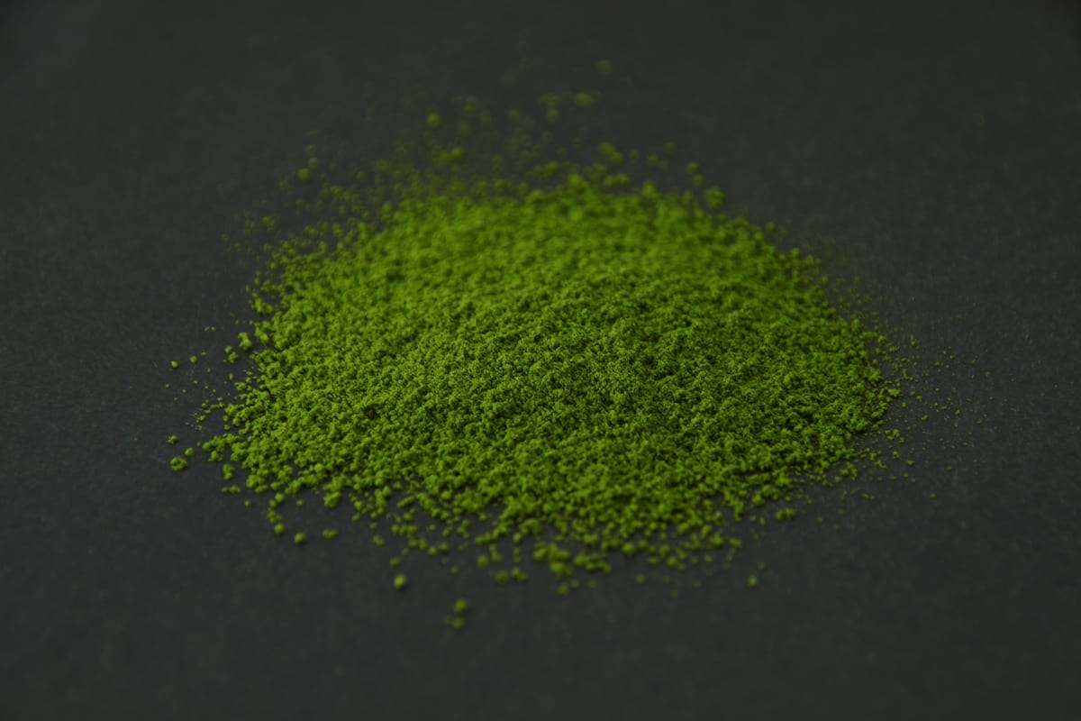 KIKU matcha powder heaped on a dark surface