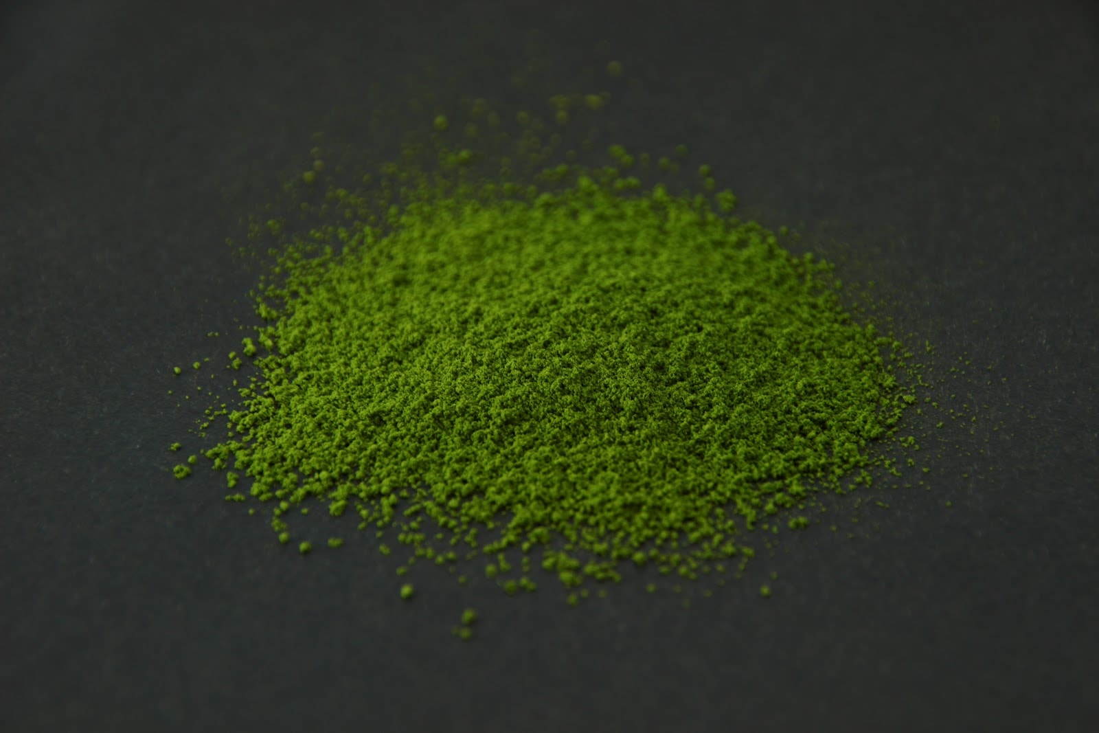 KIKU matcha powder heaped on a dark surface