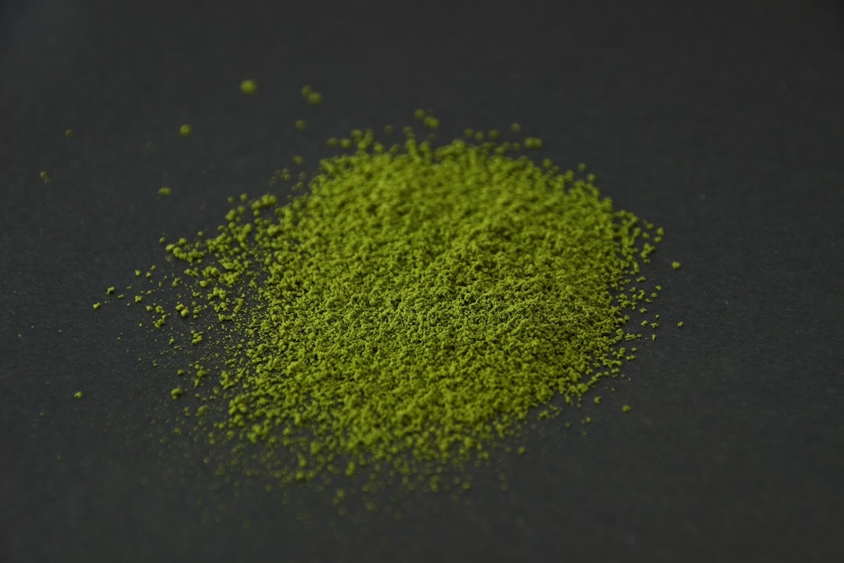 SR1 matcha powder heaped on a dark surface