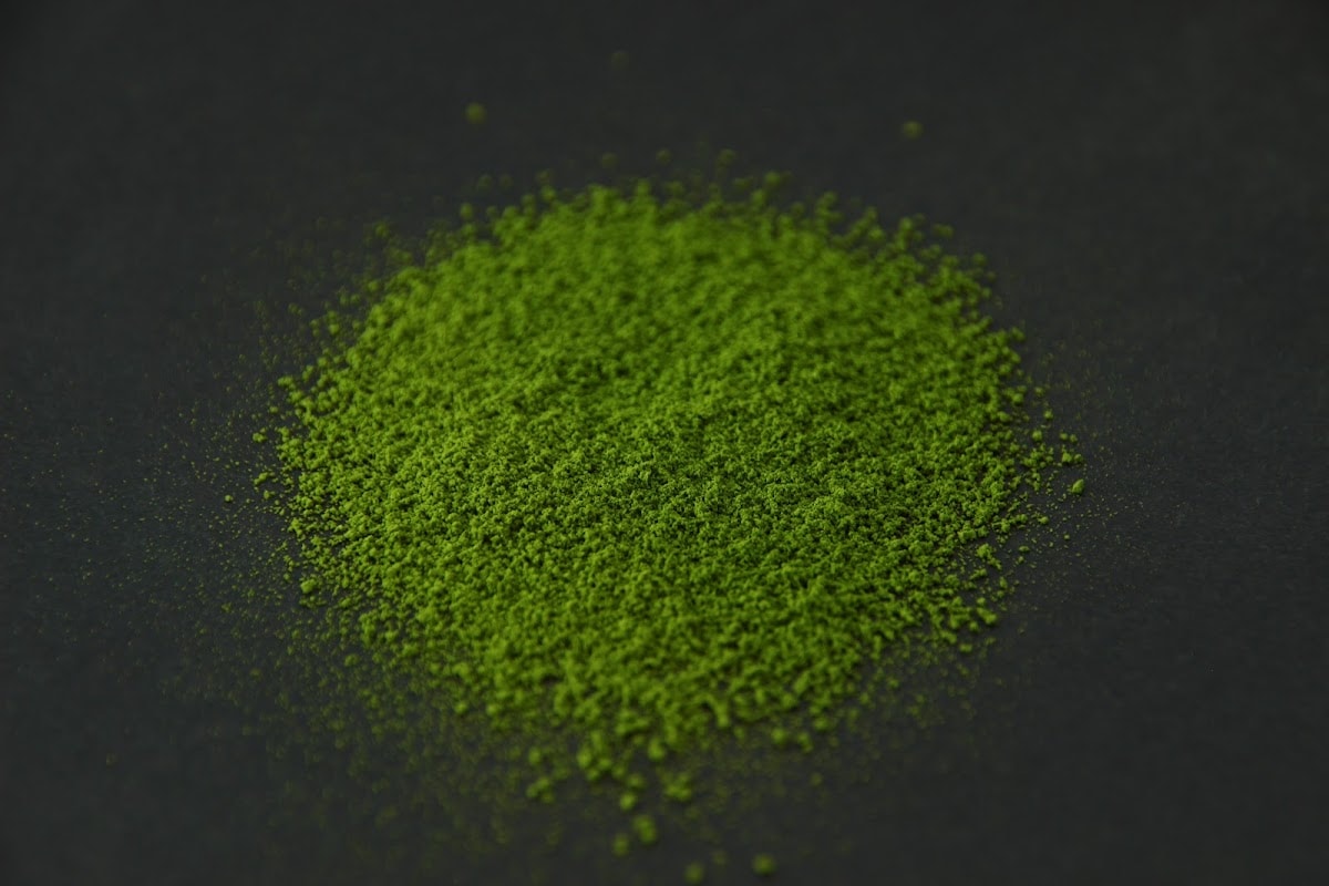 SR7 matcha powder heaped on a dark surface