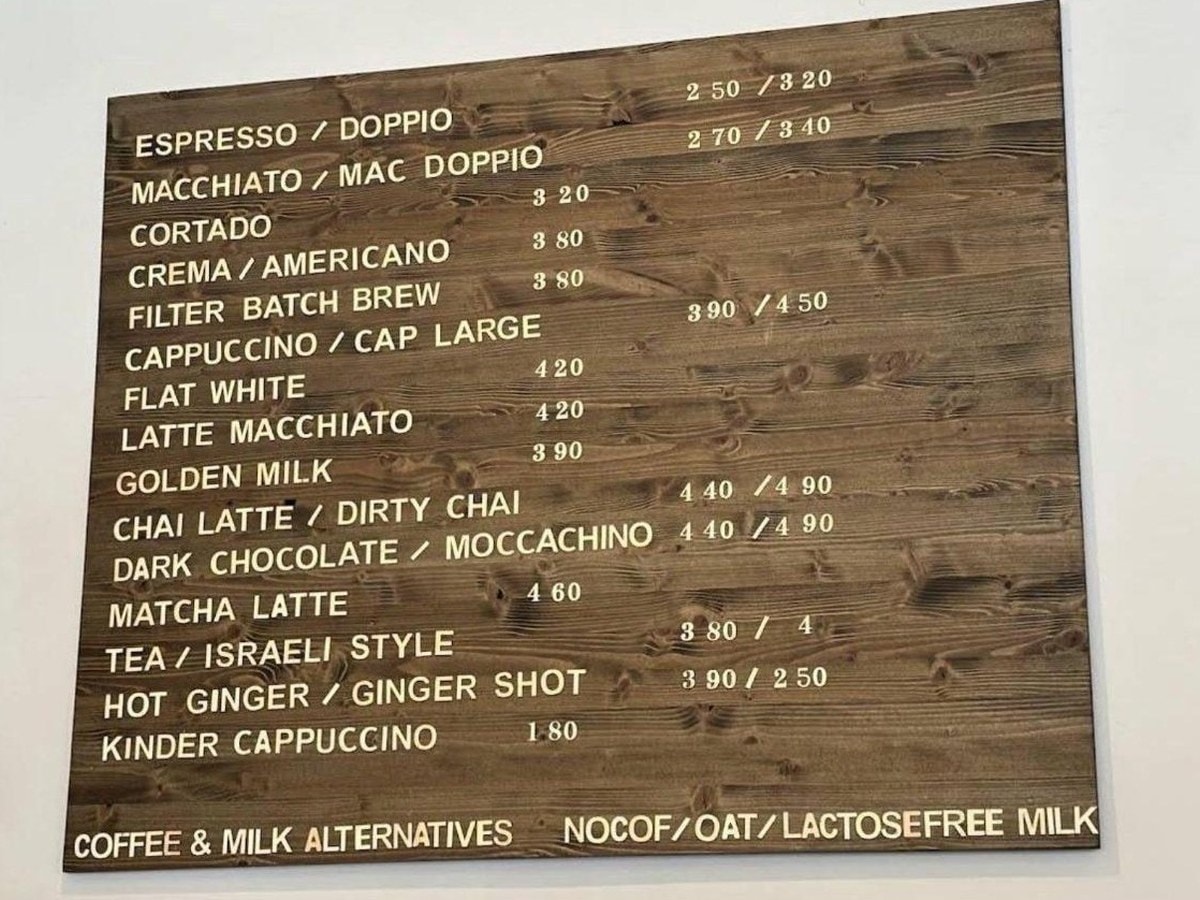Coffee Box's wooden menu board in Munich listing coffee drinks, with matcha latte at €4.60 between the chai latte and the tea