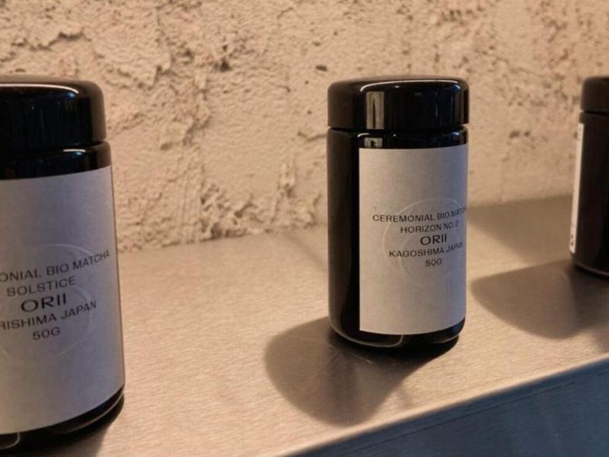 ORII's own black matcha jars on a shelf, labelled by origin: SOLSTICE from Kirishima and HORIZON NO. 2 from Kagoshima