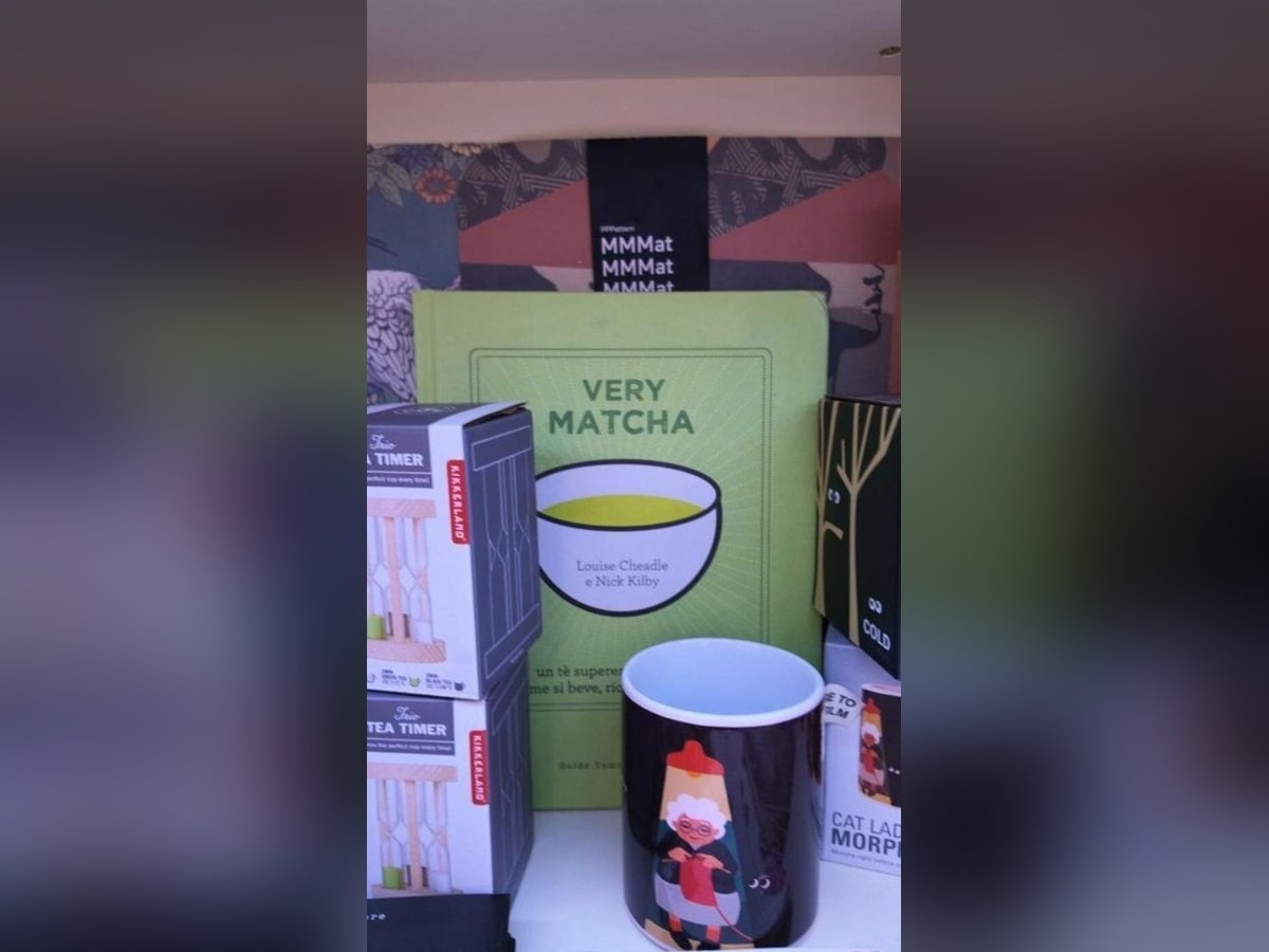 The Italian edition of the book Very Matcha displayed on a bookshop shelf next to tea mugs and accessories